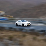 Blue McLaren 720S speeding along a mountain highway.