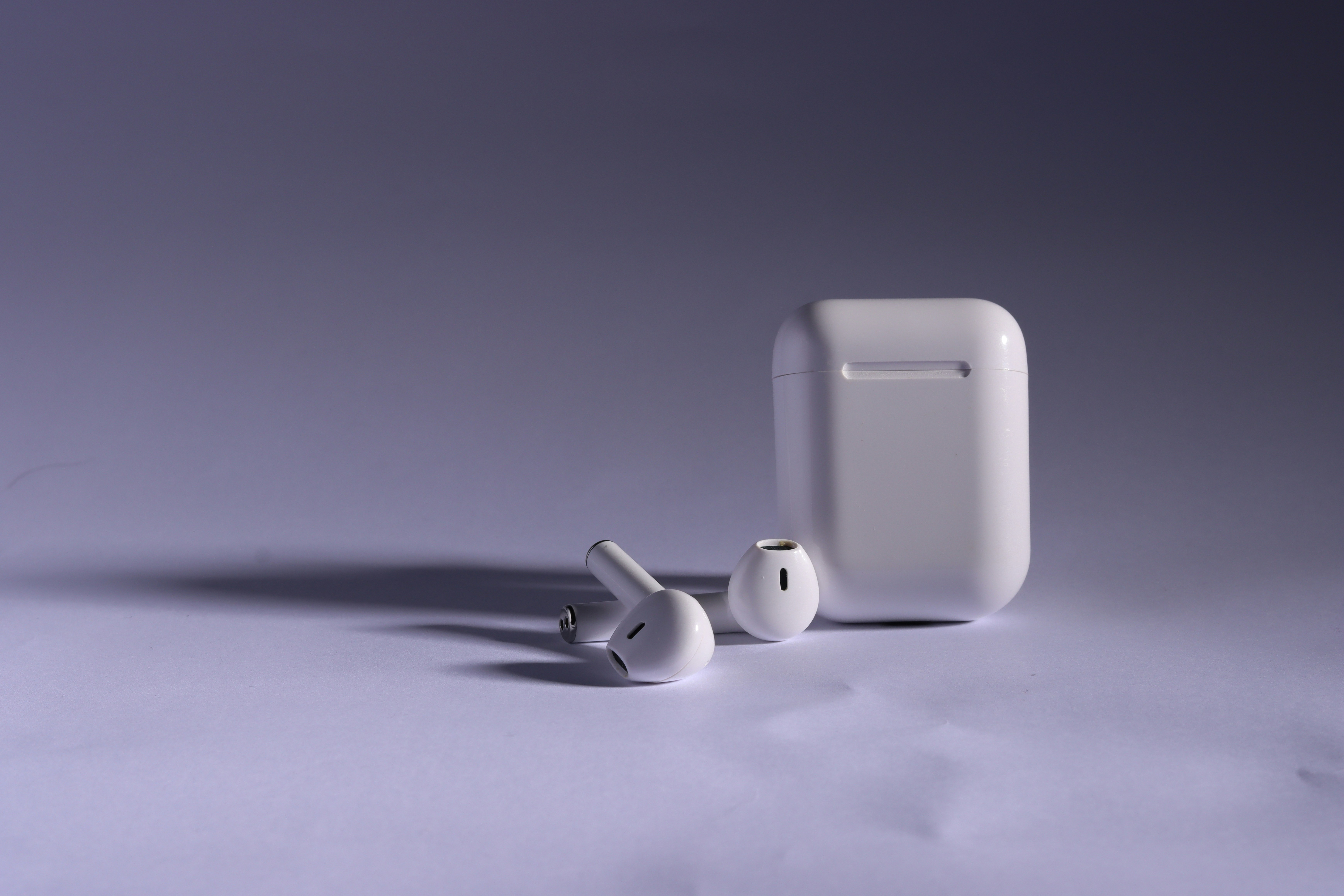 a pair of ear buds sitting next to a white case