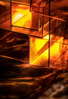Close-up of a glowing golden 3D abstract shape with glassmorphic reflections.