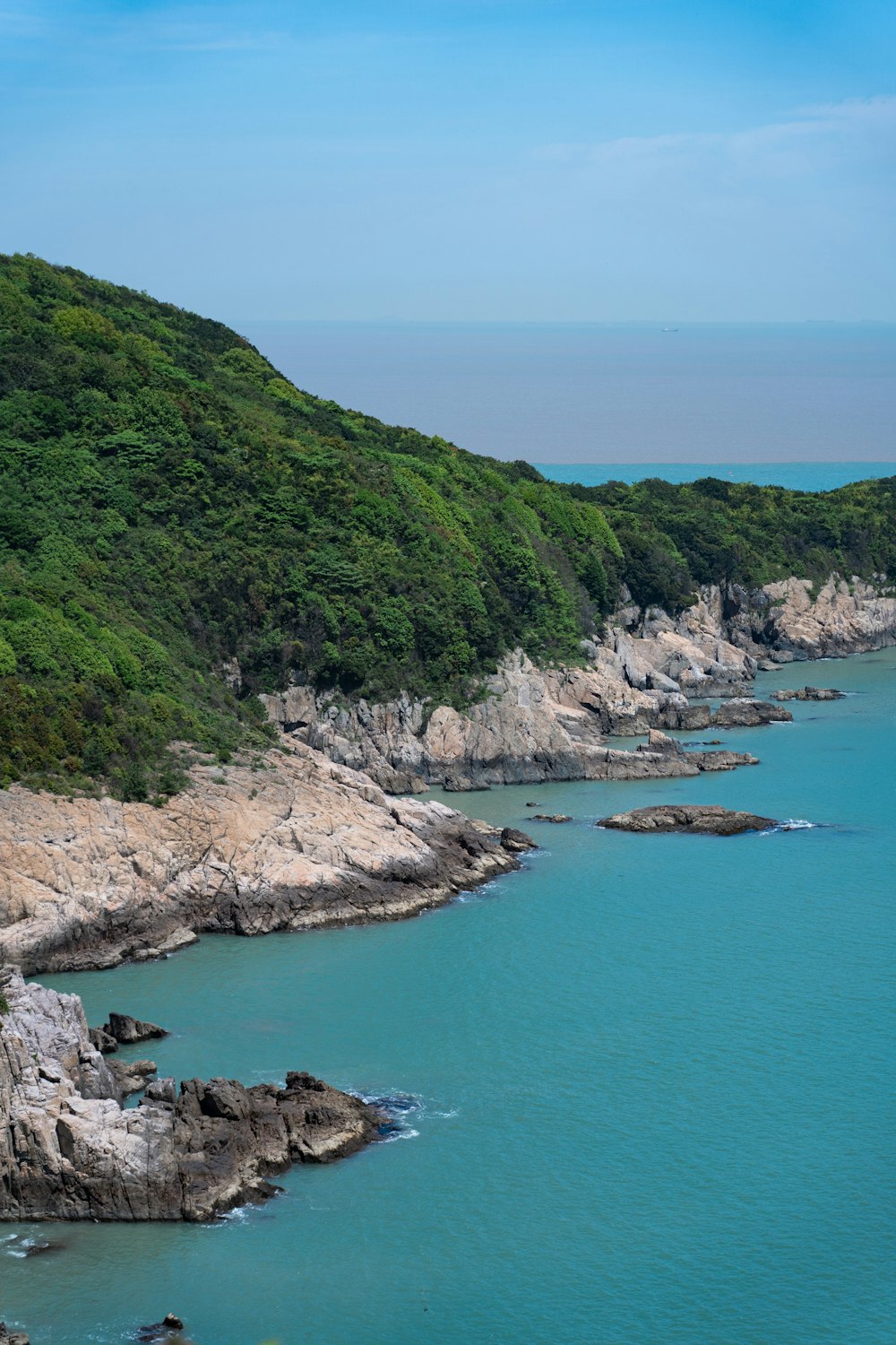 a large body of water surrounded by a lush green hillside