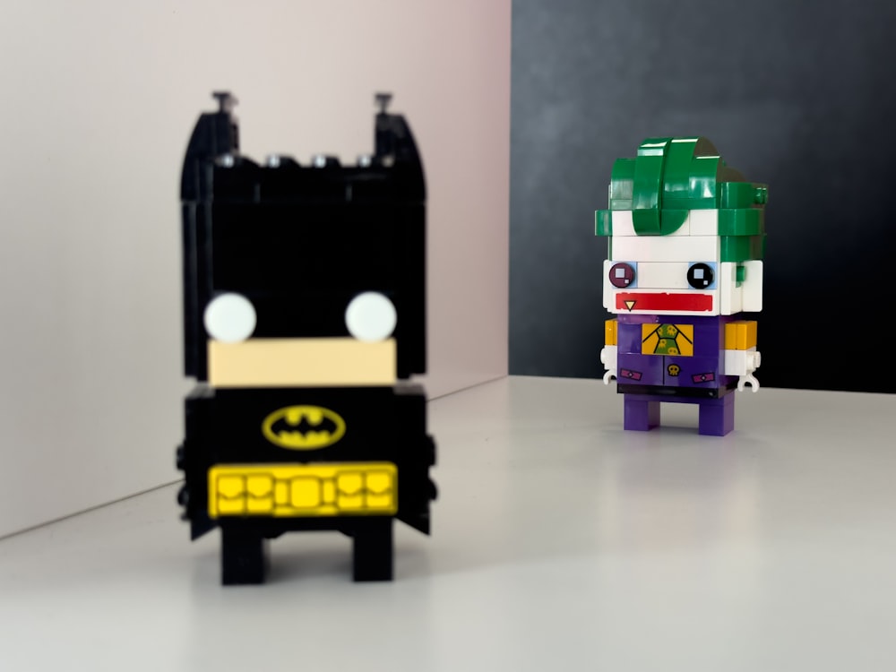 a lego batman and a lego batman standing next to each other