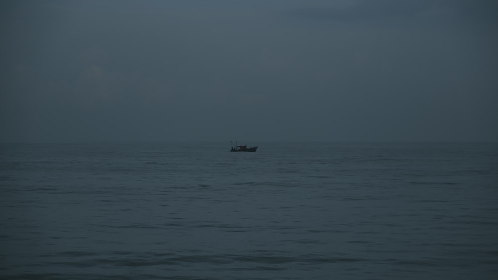 a small boat in the middle of a large body of water