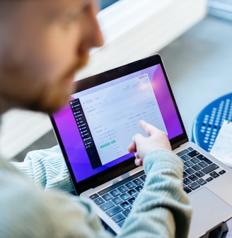 a man sitting at a table using a laptop computer