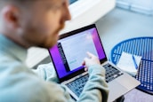 a man sitting at a table using a laptop computer
