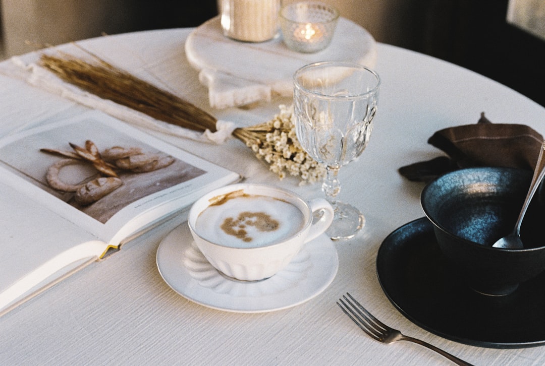 a white table topped with a cup of coffee,