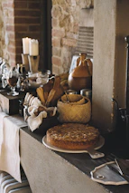 A warm, rustic kitchen scene with a baker decorating a colorful, handcrafted cake inspired by Mexican crafts.
