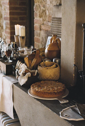 A warm kitchen scene with vibrant spices in jars and elegant stoneware dishes arranged on a wooden table.