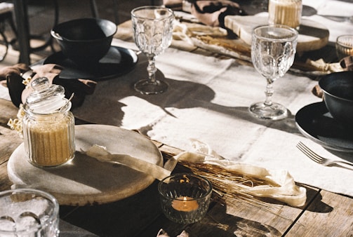 A rustic table set with syrup bottles and natural elements.
