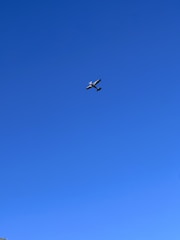 A small aircraft being prepared for takeoff on a clear runway under a bright sky.