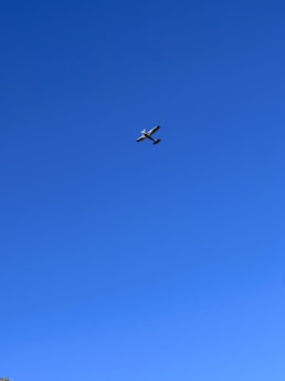 A small aircraft being prepared for takeoff on a clear runway under a bright sky.