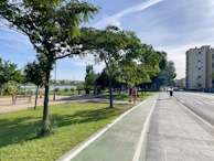 A sunny outdoor scene showing a model wearing a casual outfit, walking through a city park.