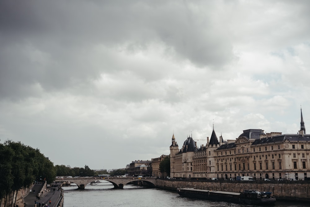 a river running through a city under a cloudy sky