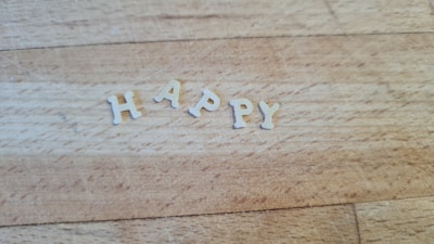 Letters spelling out the word HAPPY arranged on a wooden surface.