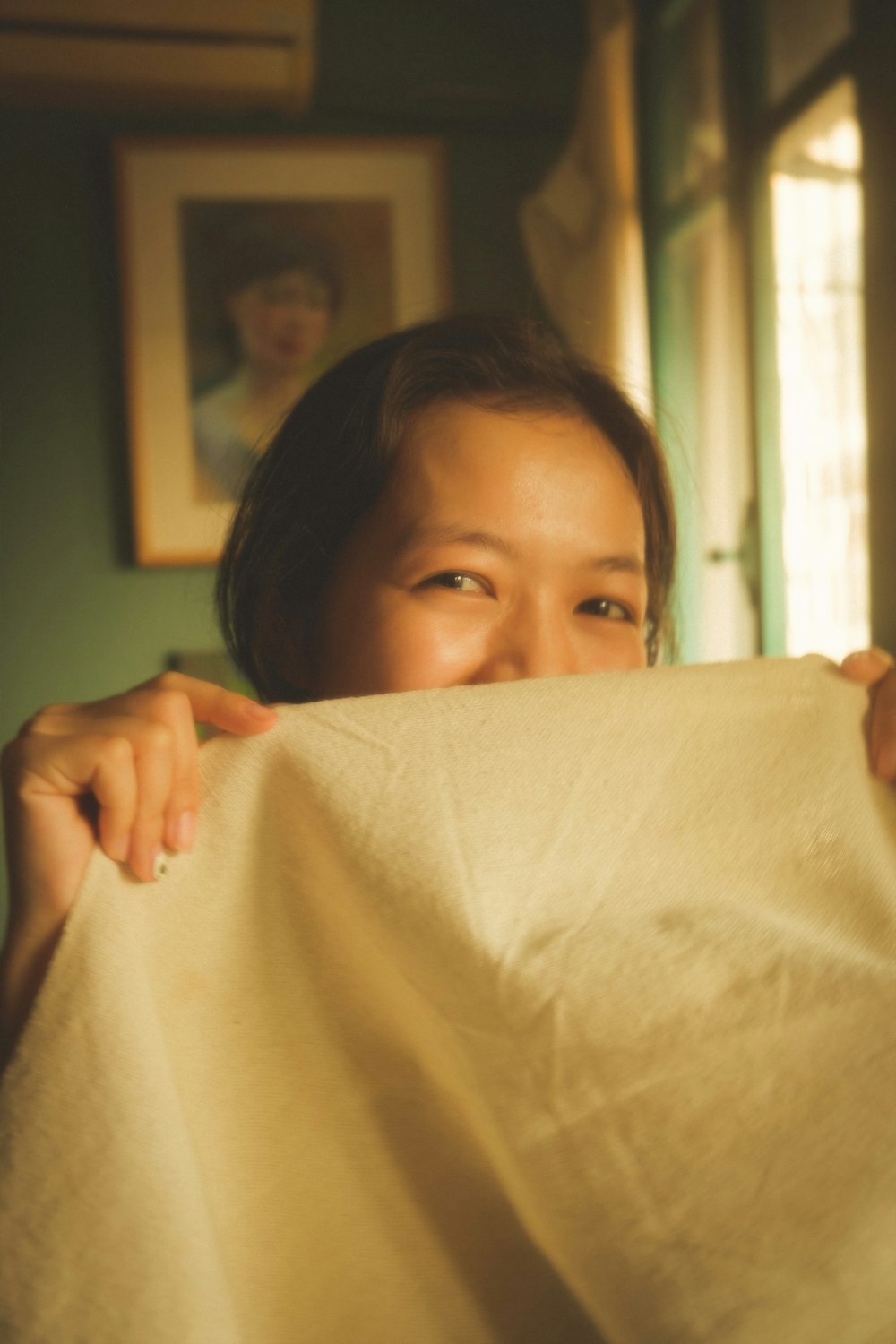 a woman holding a piece of cloth over her face