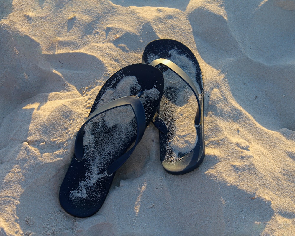 a pair of flip flops buried in the sand