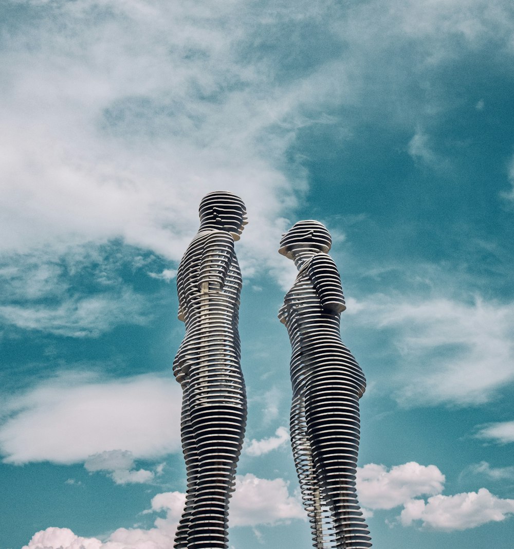 un couple de grandes statues debout l’une à côté de l’autre