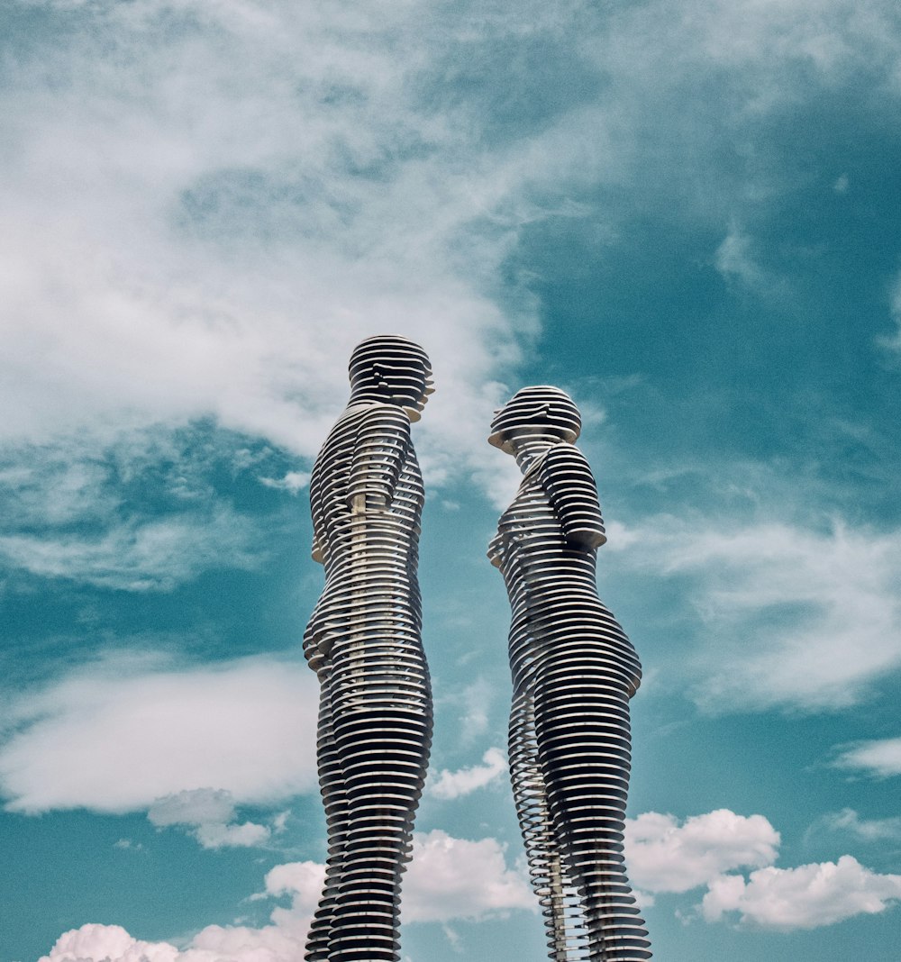 隣り合って立っている背の高い彫像のカップル