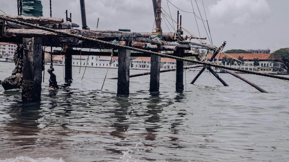 a wooden dock with ropes and ropes sticking out of the water