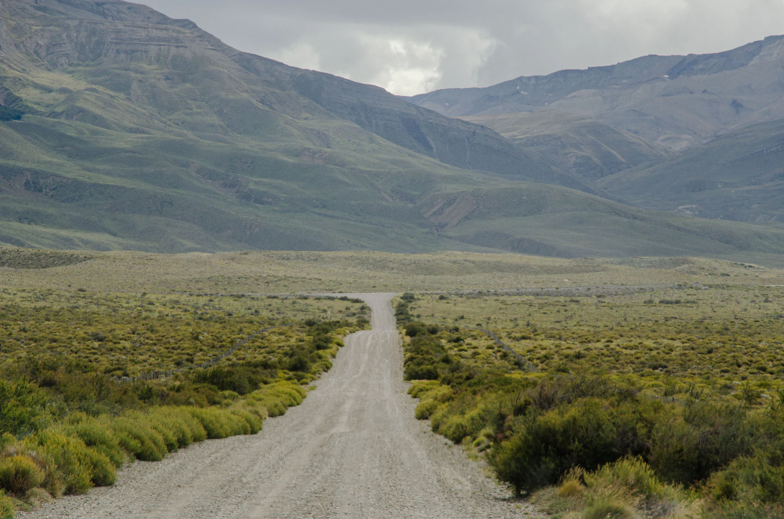 A gravel road crossing open mountain country near El Chaltén