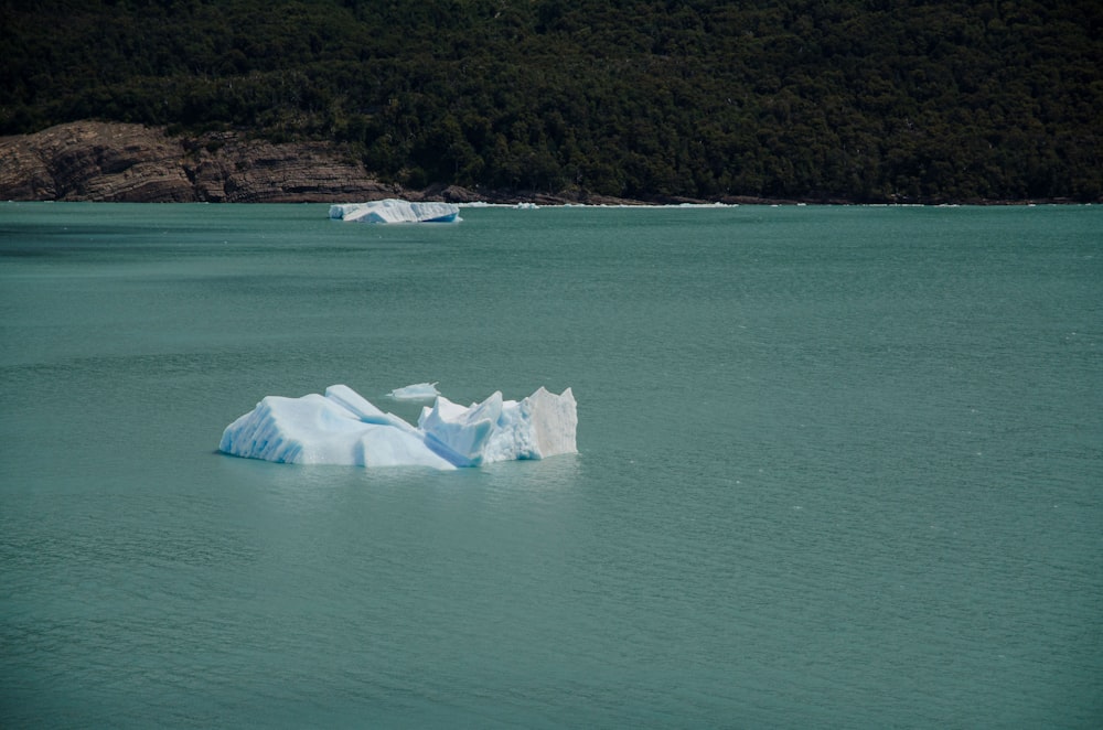 a large iceberg floating in the middle of a lake