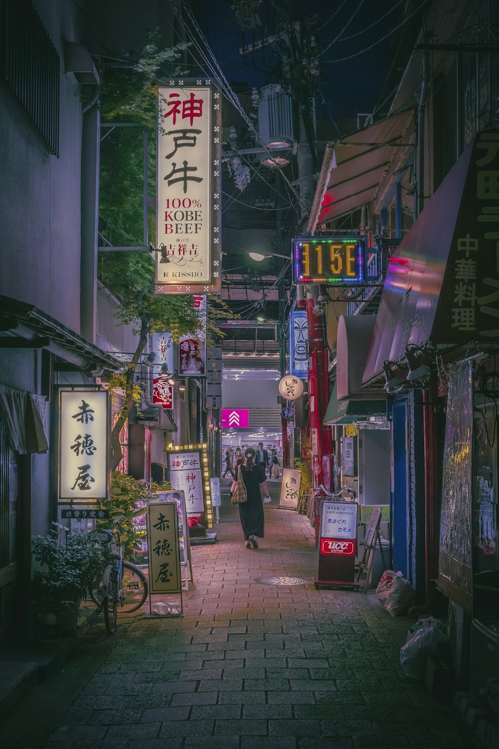 a person walking down a narrow street at night
