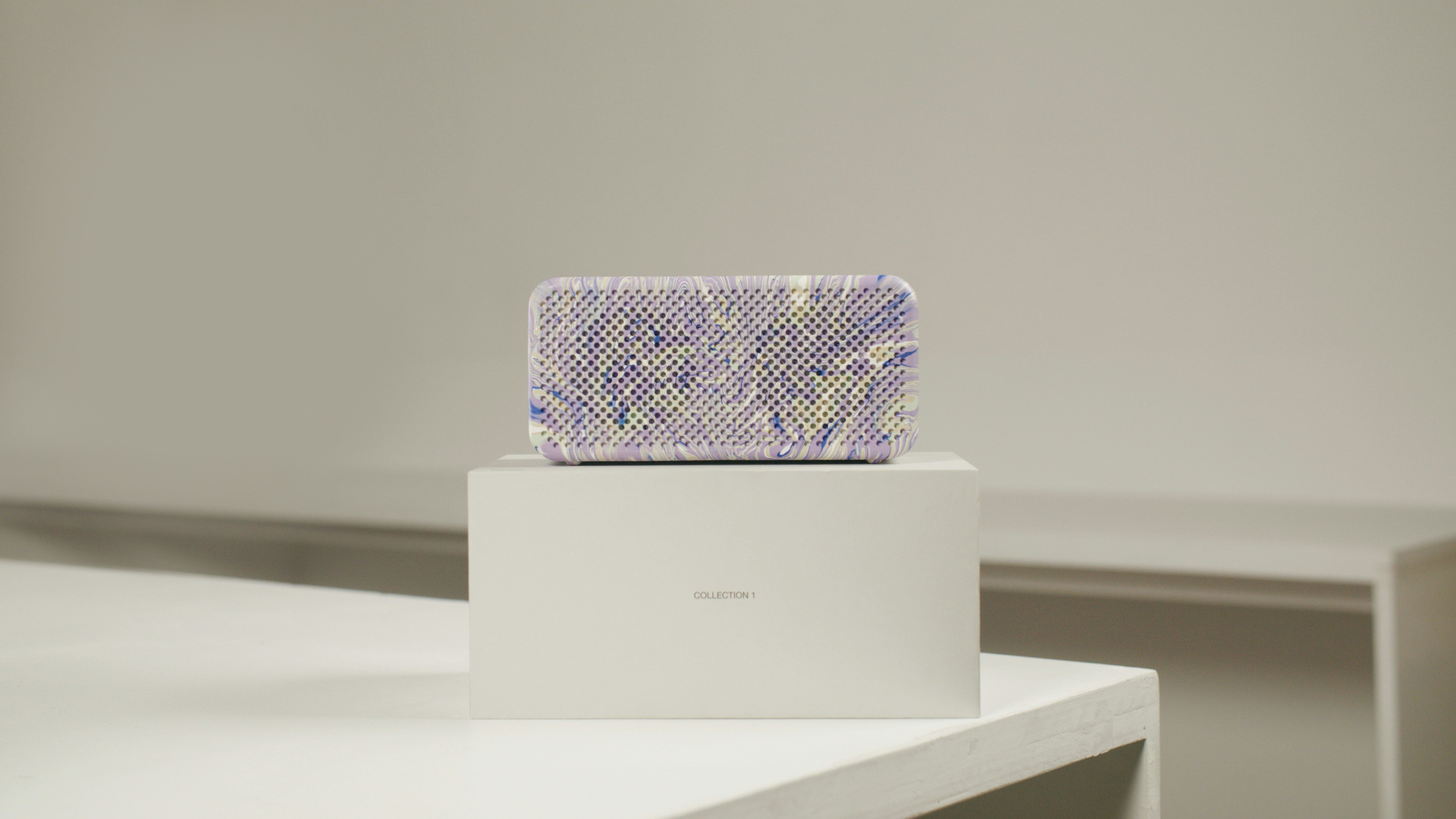 a white box with a purple and blue purse on top of it