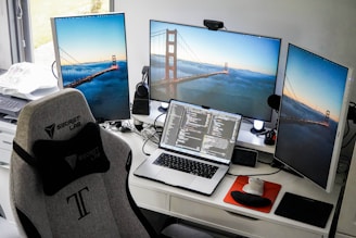 a desk with two monitors and a laptop