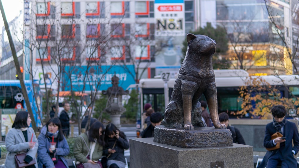 Una estatua de un perro sentado encima de un bloque de cemento
