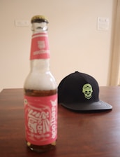 A close-up of a vibrant, uniquely designed water bottle with the Laughing Dead MC Inc logo, set against a rustic wooden background.