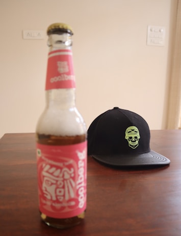 A close-up of a vibrant, uniquely designed water bottle with the Laughing Dead MC Inc logo, set against a rustic wooden background.