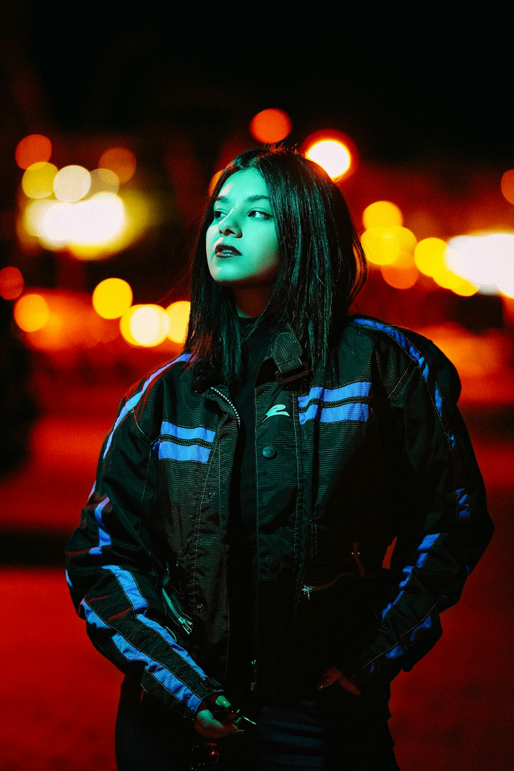 a woman standing in the street at night