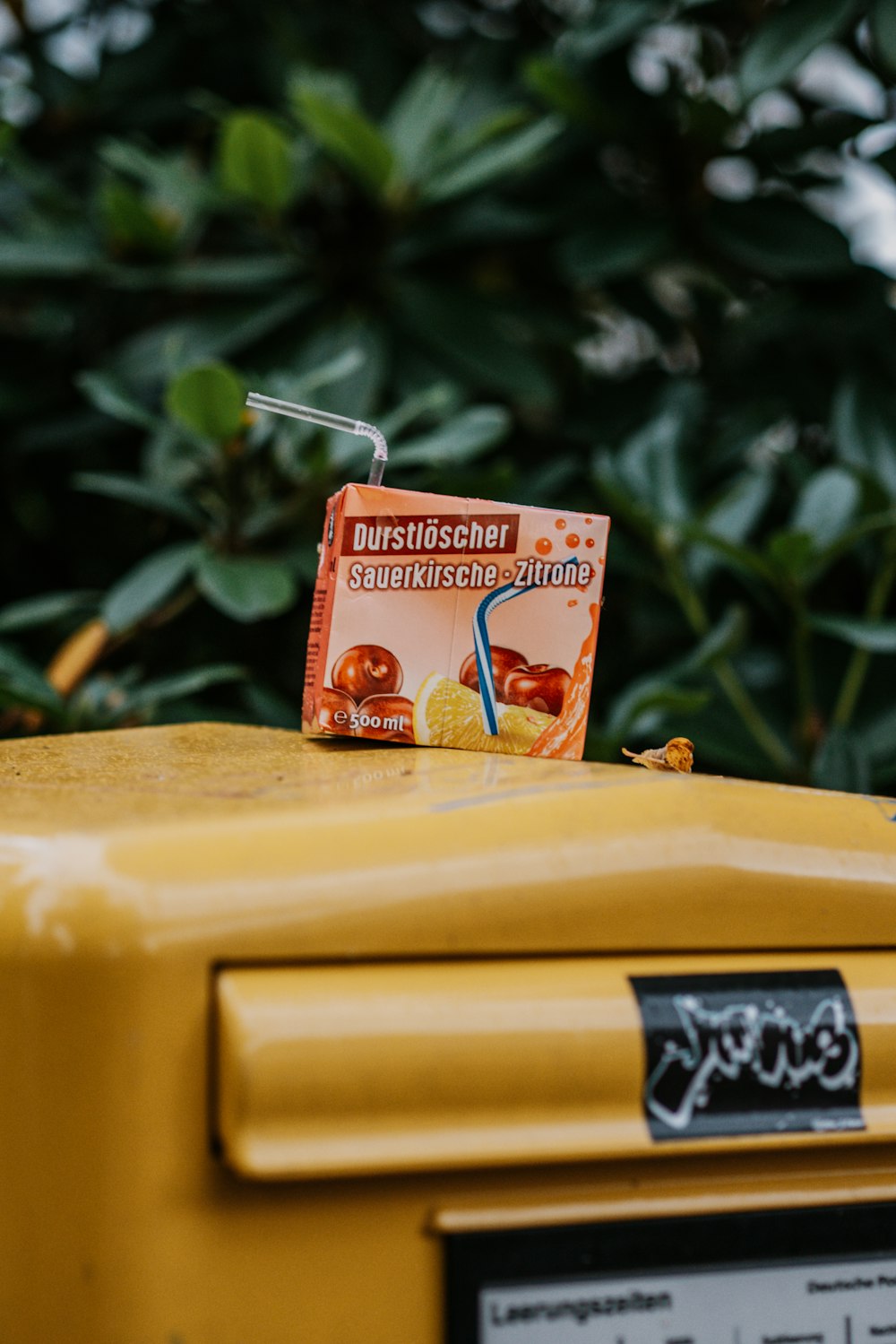 a box of orange juice with a straw sticking out of it