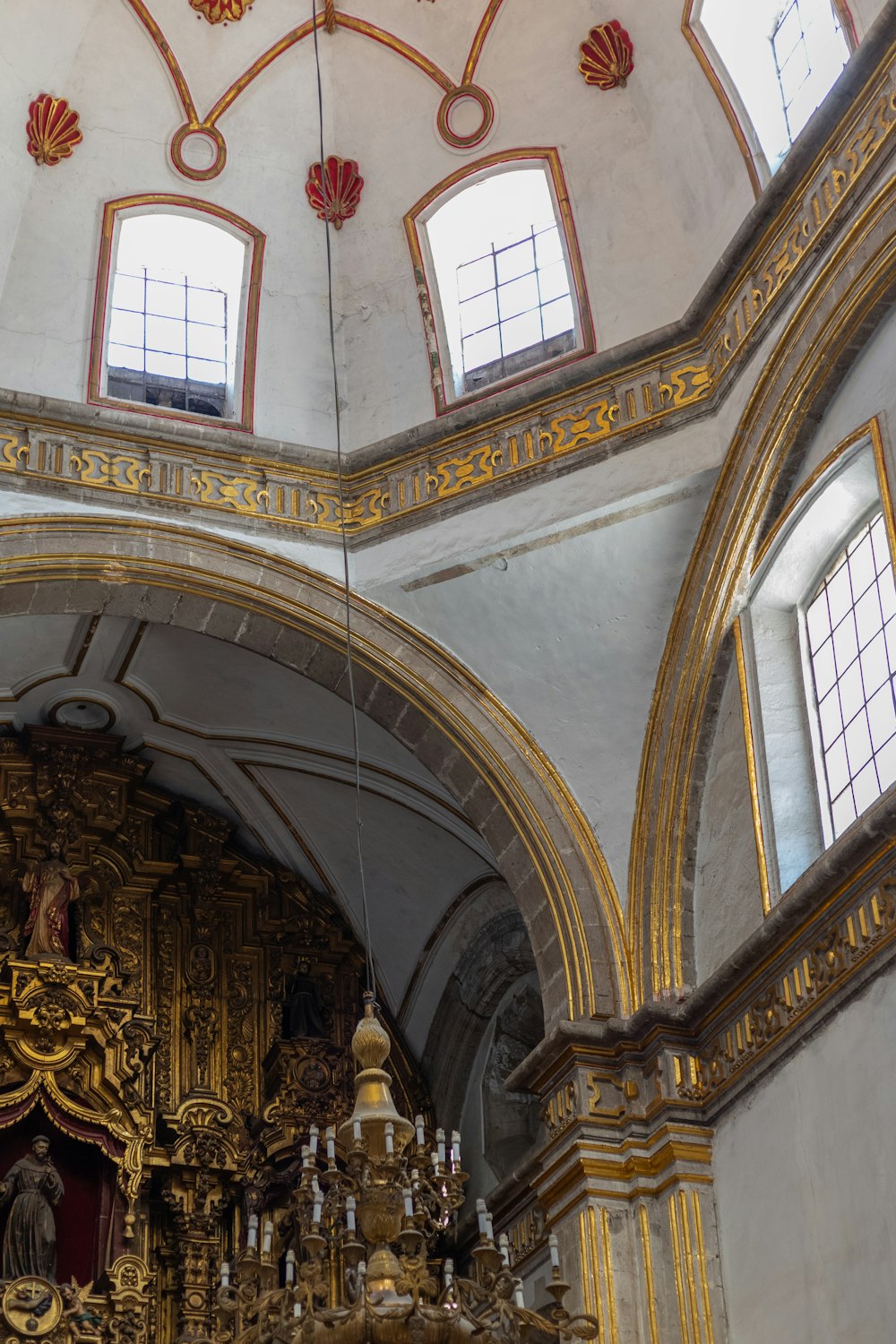 a church with a gold alter and chandelier