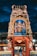An intricately designed Hindu temple facade featuring vibrant statues of deities adorned with vivid colors and elaborate detailing, set against a dramatic evening sky.