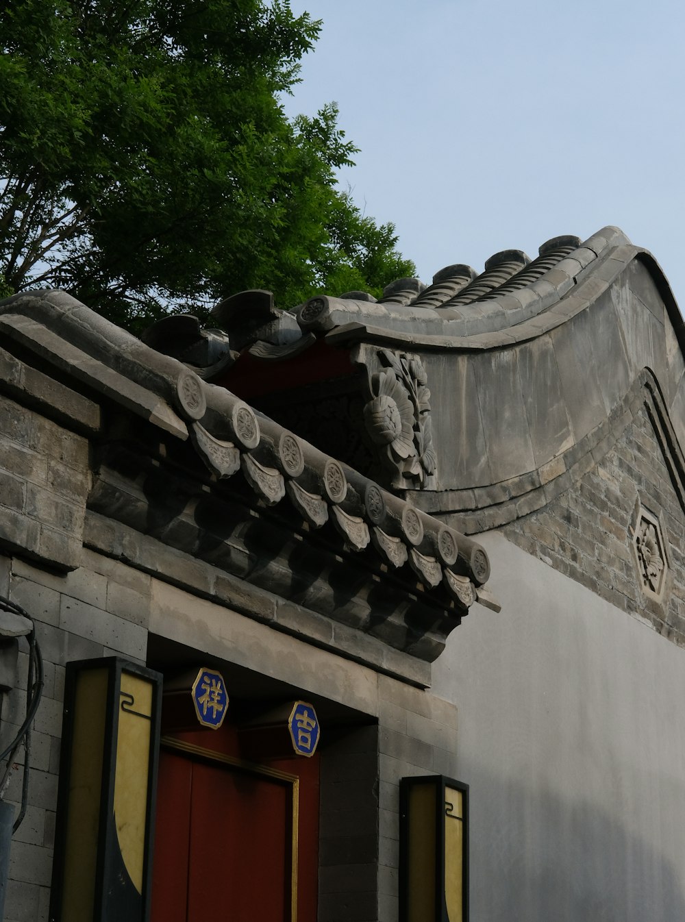 a building with a red door and a tree in the background