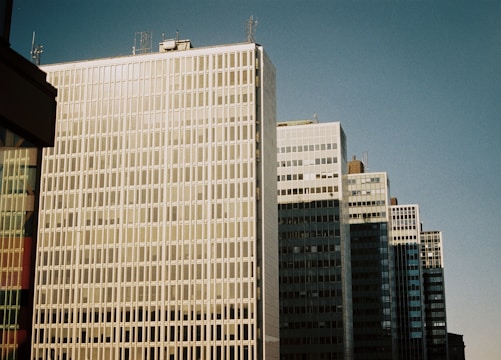 A row of durable office building windows reflecting the sky.