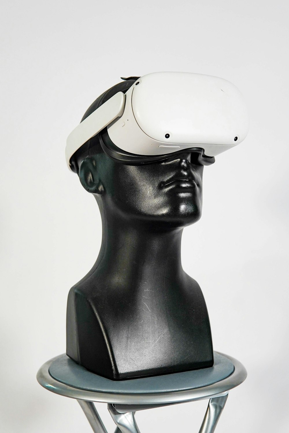 a black mannequin head with a white hat on top of it