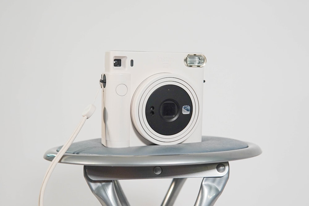 a white camera sitting on top of a metal table
