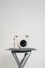 A sleek red and white video camera setup on a minimalist white table.
