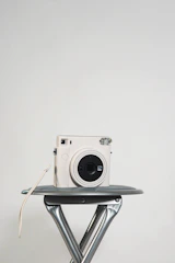 Minimalist sliding photo book with Instax prints displayed on a clean white surface.