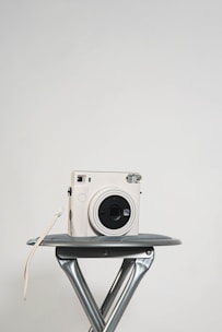 A sleek red and white video camera setup on a minimalist white table.