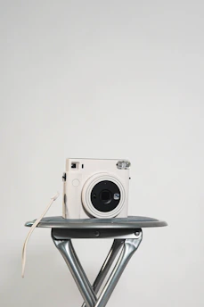 Minimalist sliding photo book with Instax prints displayed on a clean white surface.