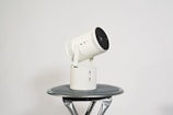 A white telescopic camera sitting on top of a table