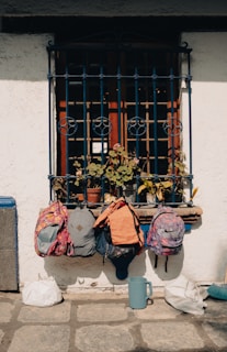 a couple of backpacks sitting on a window sill