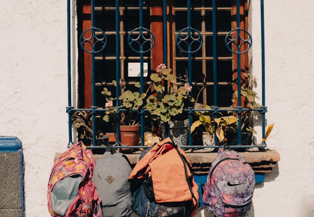 a couple of backpacks sitting on a window sill