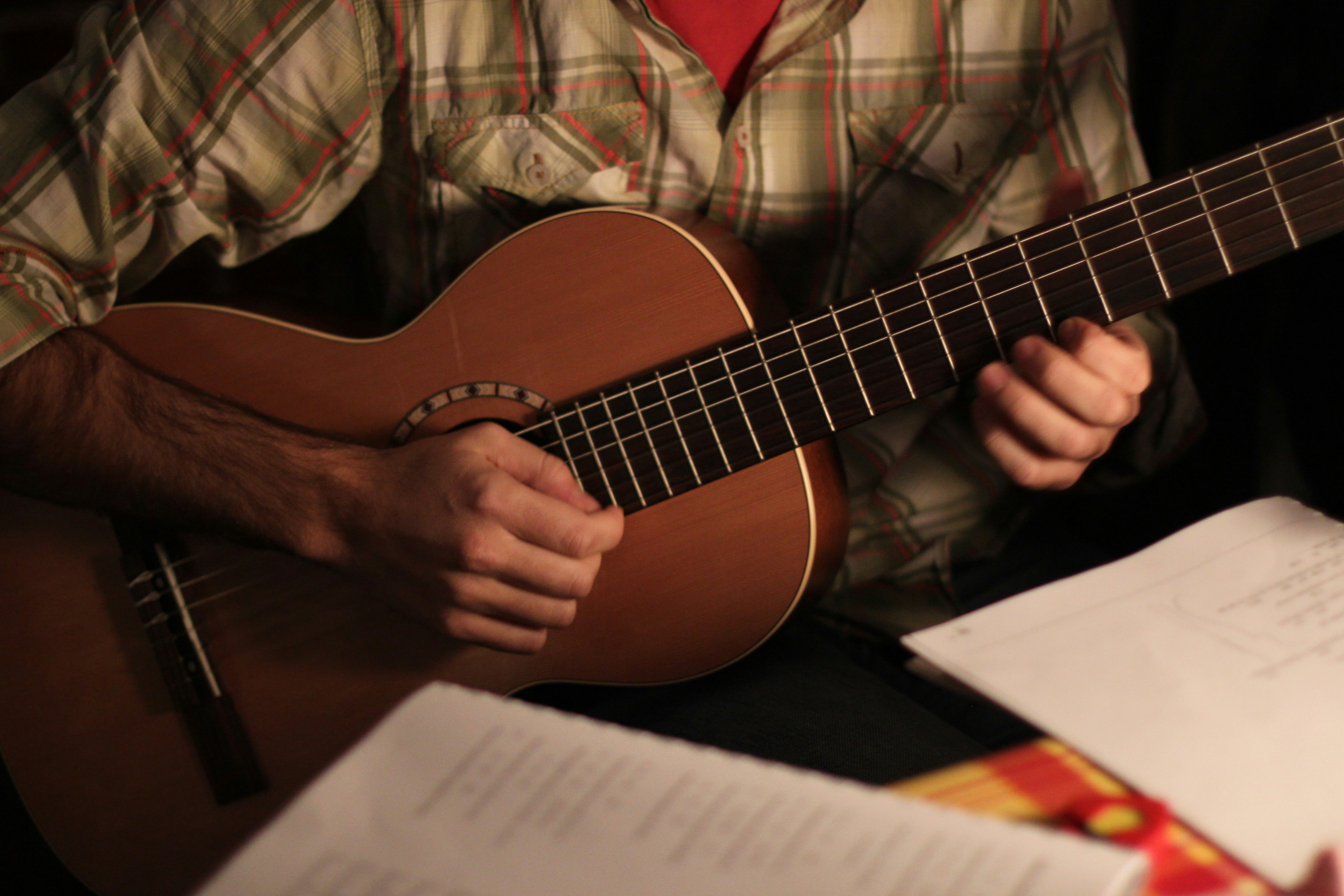 a man is playing a guitar on a table