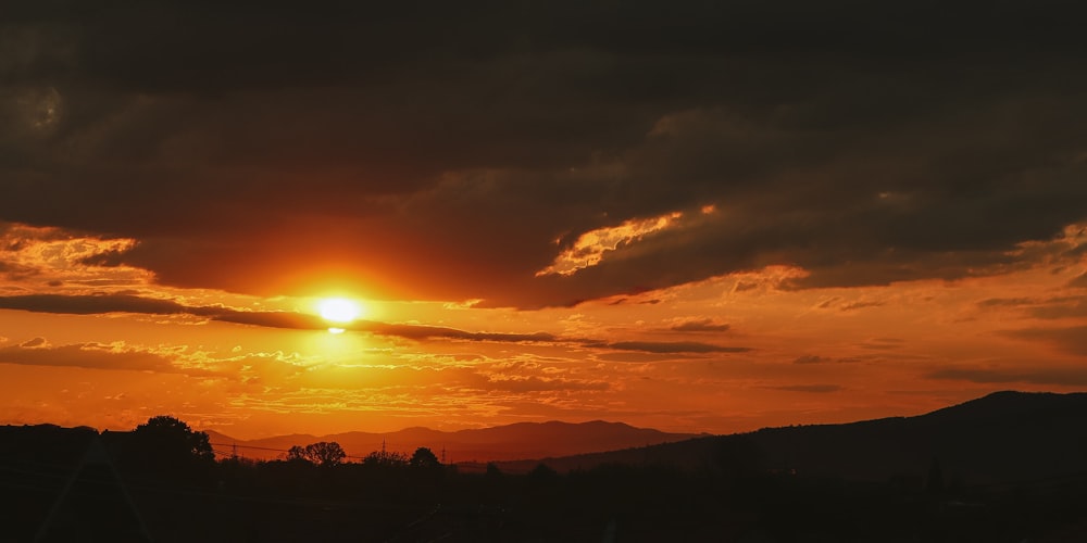 the sun is setting over a mountain range