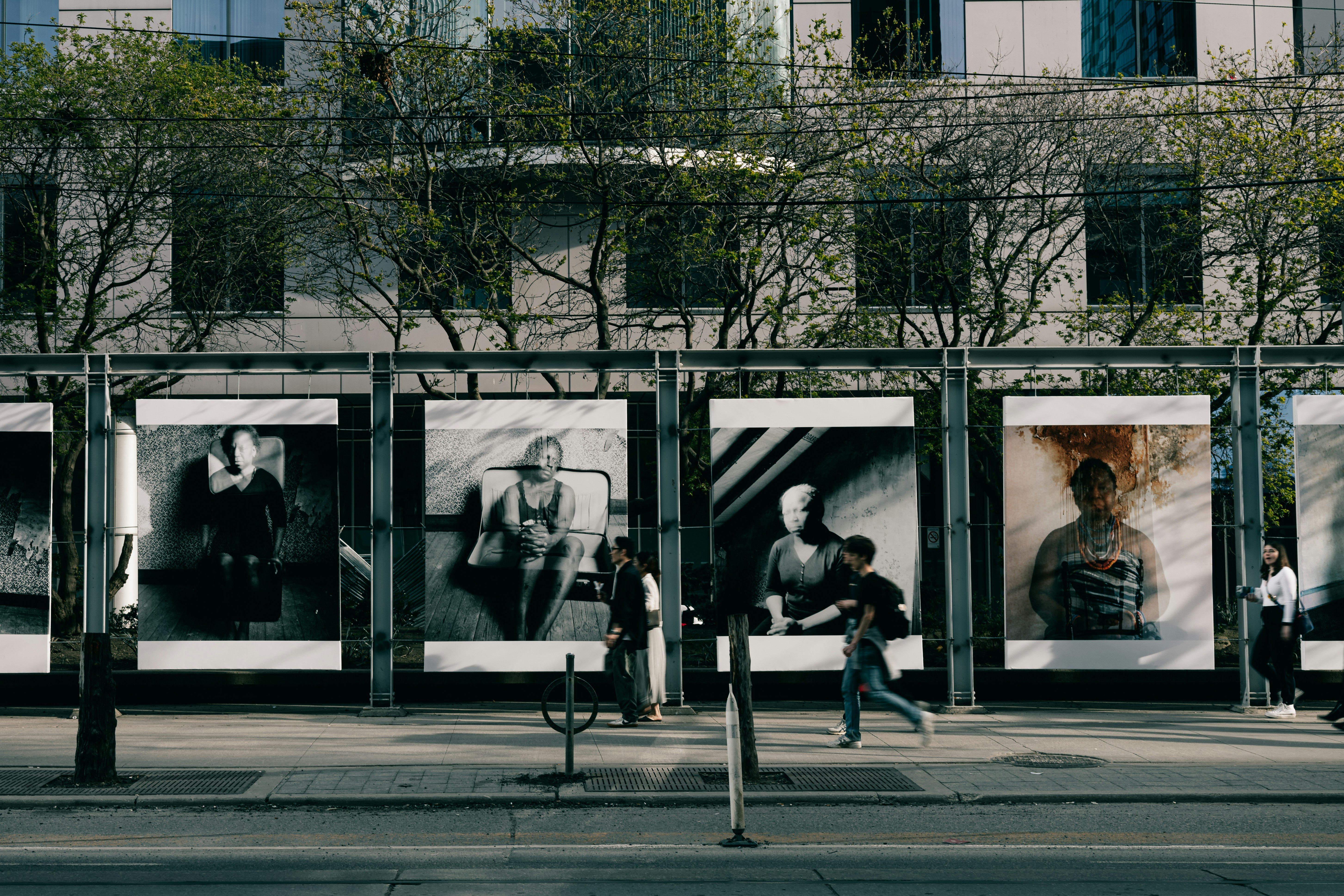 a group of people walking down a street next to a tall building