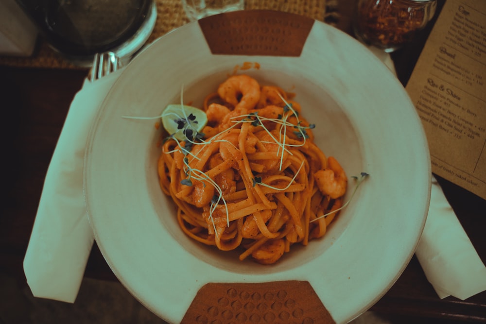 a white plate topped with pasta covered in sauce