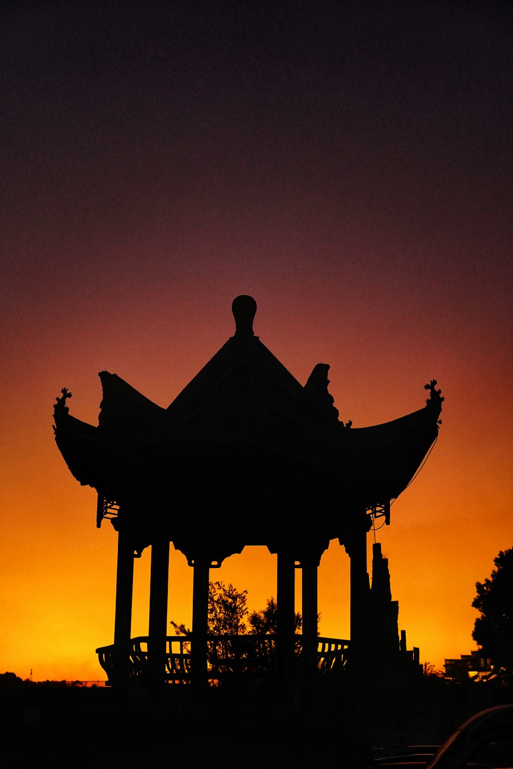 a silhouette of a gazebo at sunset